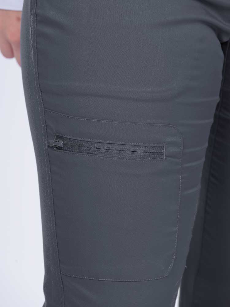 Young female nurse wearing an Epic by MedWorks Women's Blessed Skinny Yoga Scrub Pant in pewter with 1 zip closure cargo pant on the wearer's right.