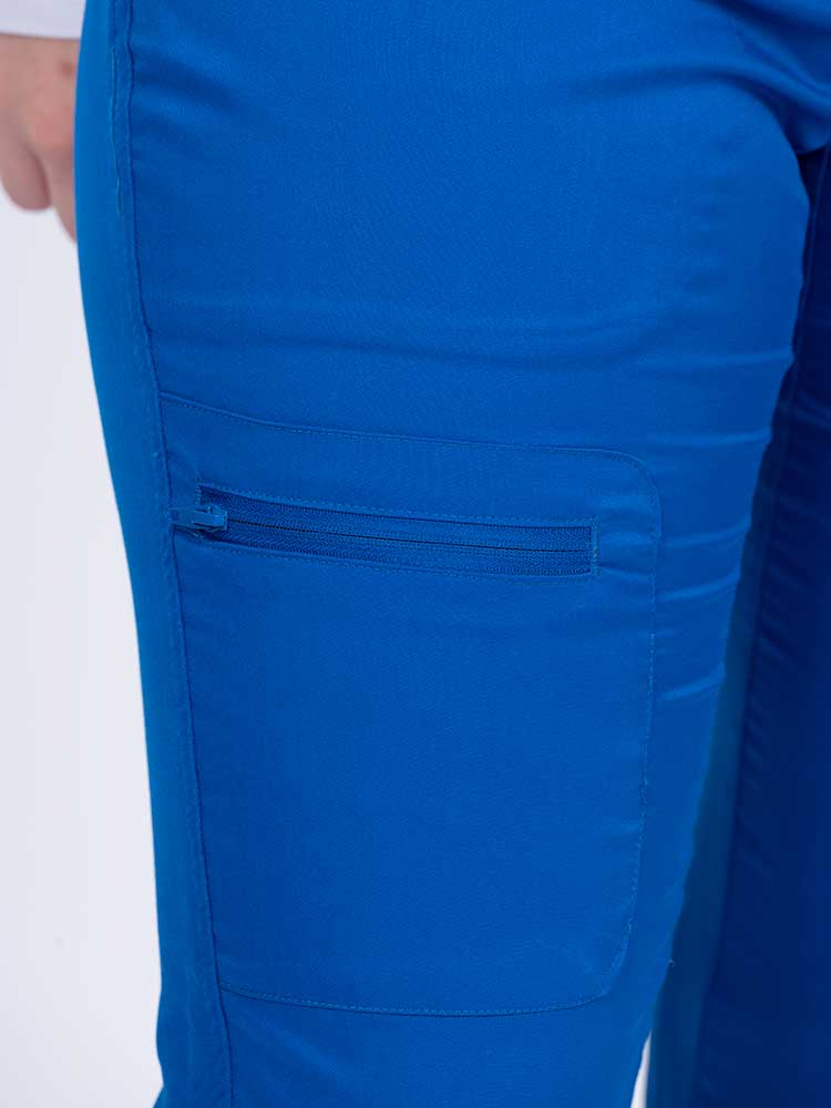 Young female nurse wearing an Epic by MedWorks Women's Blessed Skinny Yoga Scrub Pant in royal with 1 zip closure cargo pant on the wearer's right.