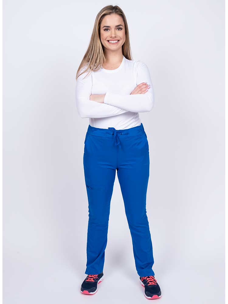 Young woman wearing an Epic by MedWorks Women's Blessed Skinny Yoga Scrub Pant in royal with an adjustable waistband.