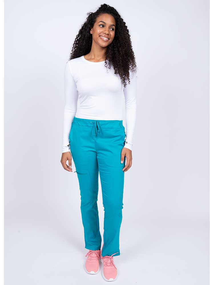 Young woman wearing an Epic by MedWorks Women's Blessed Skinny Yoga Scrub Pant in teal with an adjustable waistband.