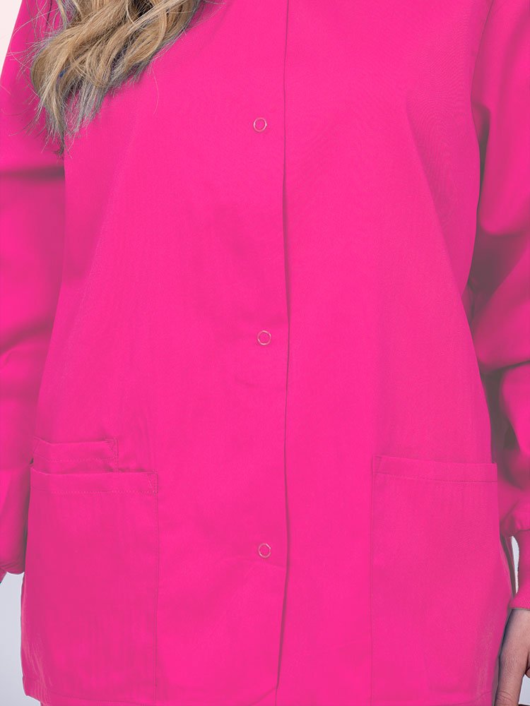 Young nurse wearing an Epic by MedWorks Women's Snap Front Scrub Jacket in shocking pink with color matched metal snap closure.