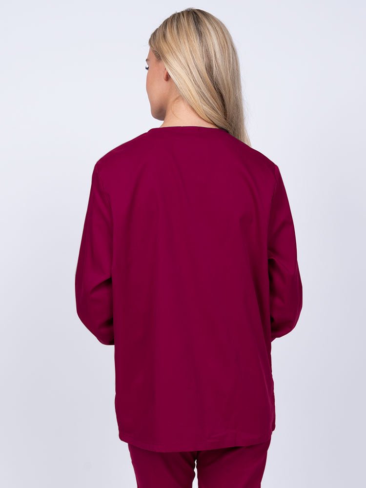 Young nurse wearing an Epic by MedWorks Women's Snap Front Scrub Jacket in wine featuring a missy fit & a round neck.
