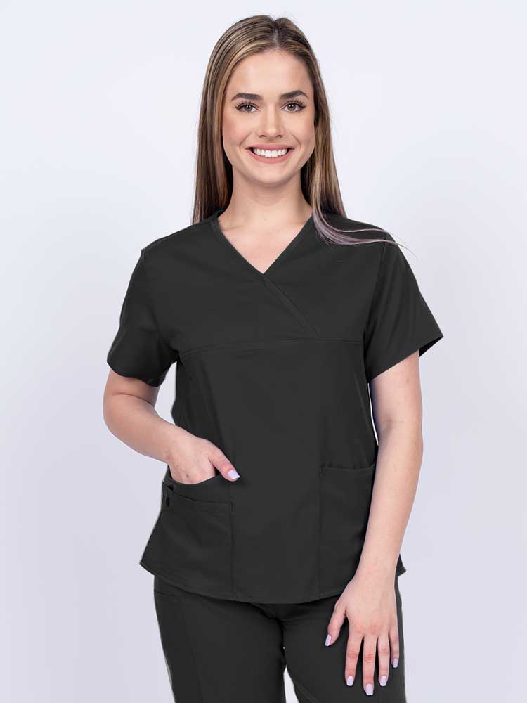 Woman wearing an Epic by MedWorks Women's Y-Neck Scrub Top in black with a super soft, 2-way stretch fabric designed to move with your body all day long.