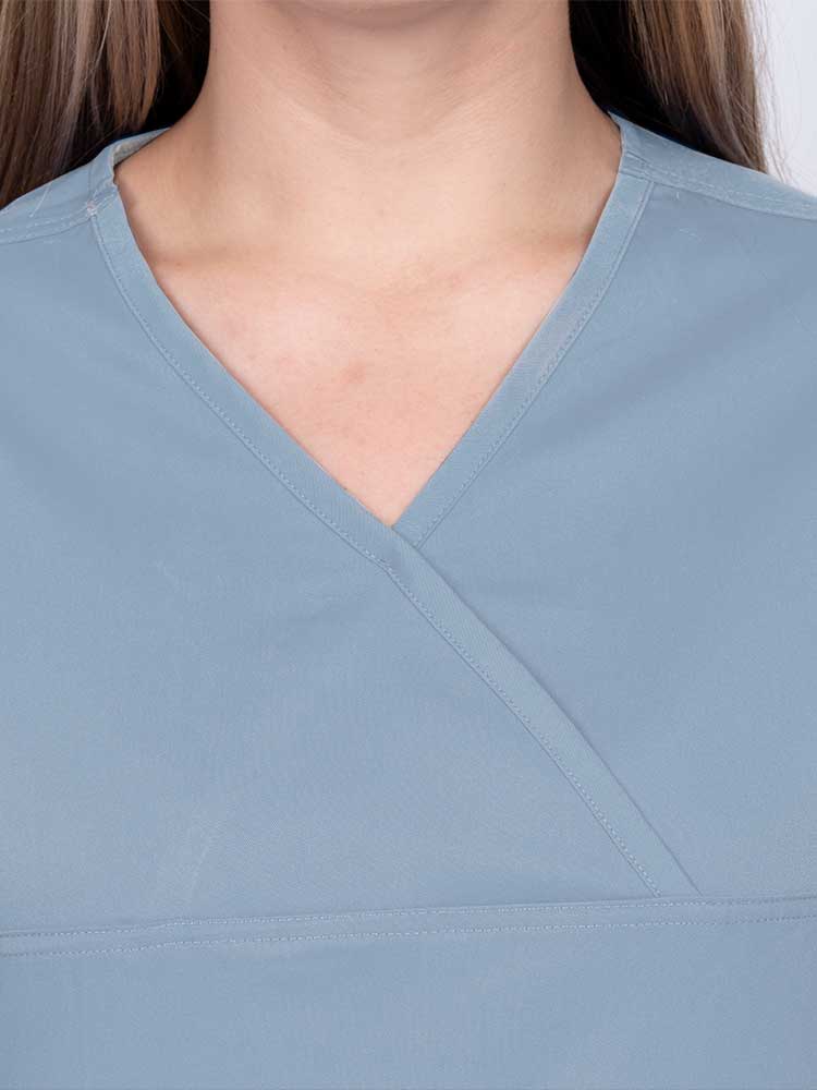 Woman wearing an Epic by MedWorks Women's Scrub Top in blue fog with a Y-neckline.