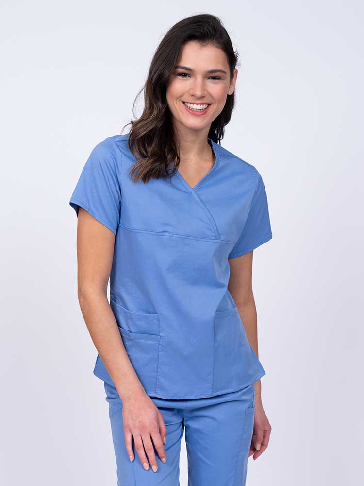 Woman wearing an Epic by MedWorks Women's Y-Neck Scrub Top in ceil with a super soft, 2-way stretch fabric designed to move with your body all day long.