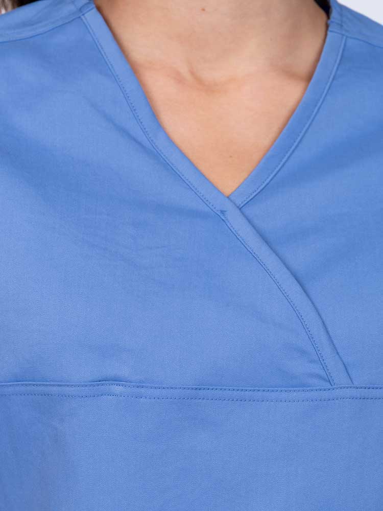 Woman wearing an Epic by MedWorks Women's Scrub Top in blue fog with a Y-neckline.