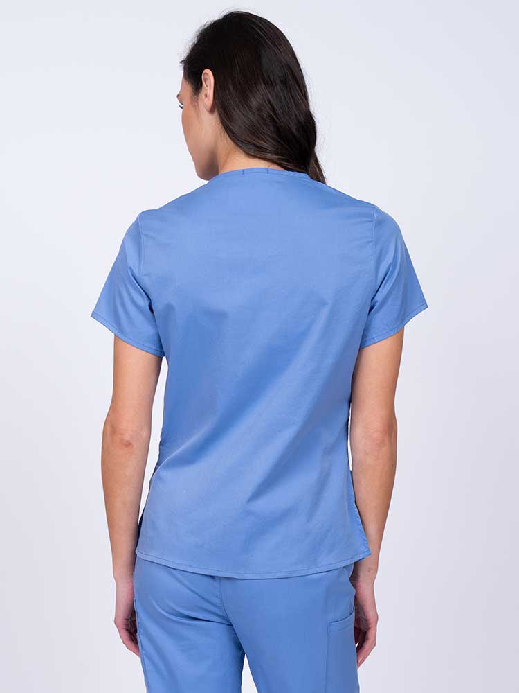 Woman wearing an Epic by MedWorks Women's Y-Neck Scrub Top in blue fog with a center back length of 26".