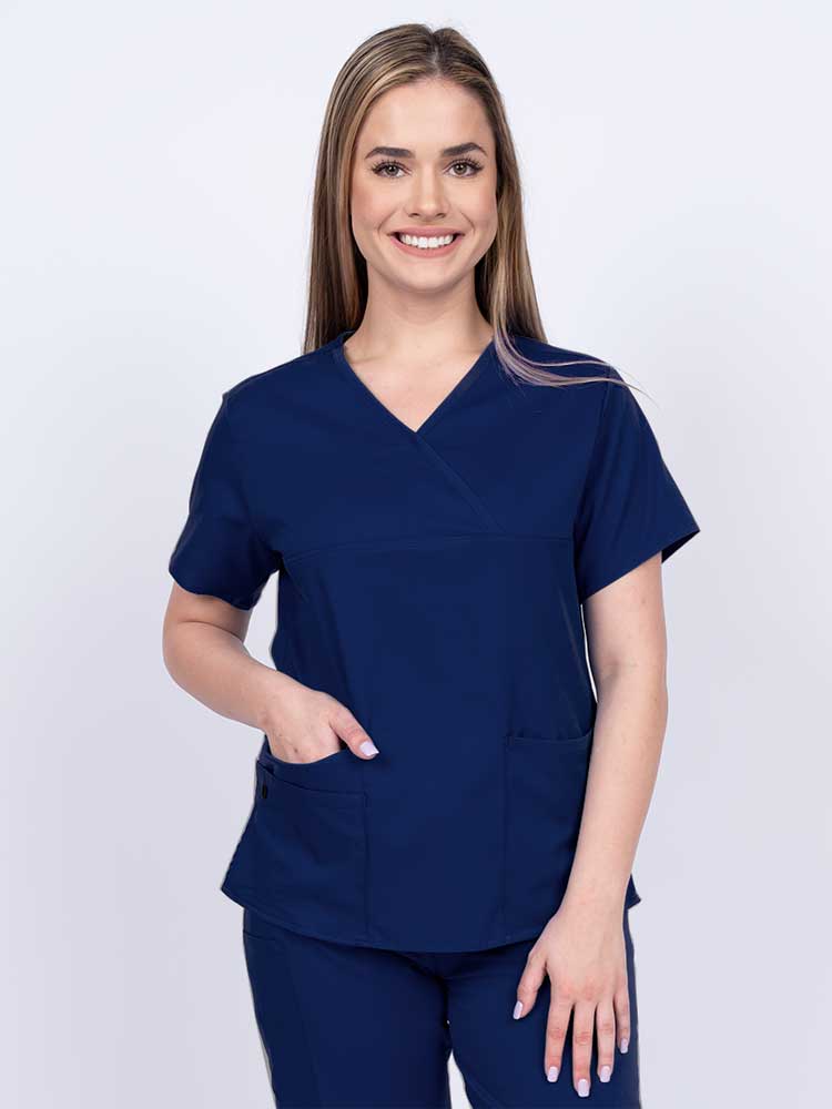 Woman wearing an Epic by MedWorks Women's Y-Neck Scrub Top in navy with a super soft, 2-way stretch fabric designed to move with your body all day long.