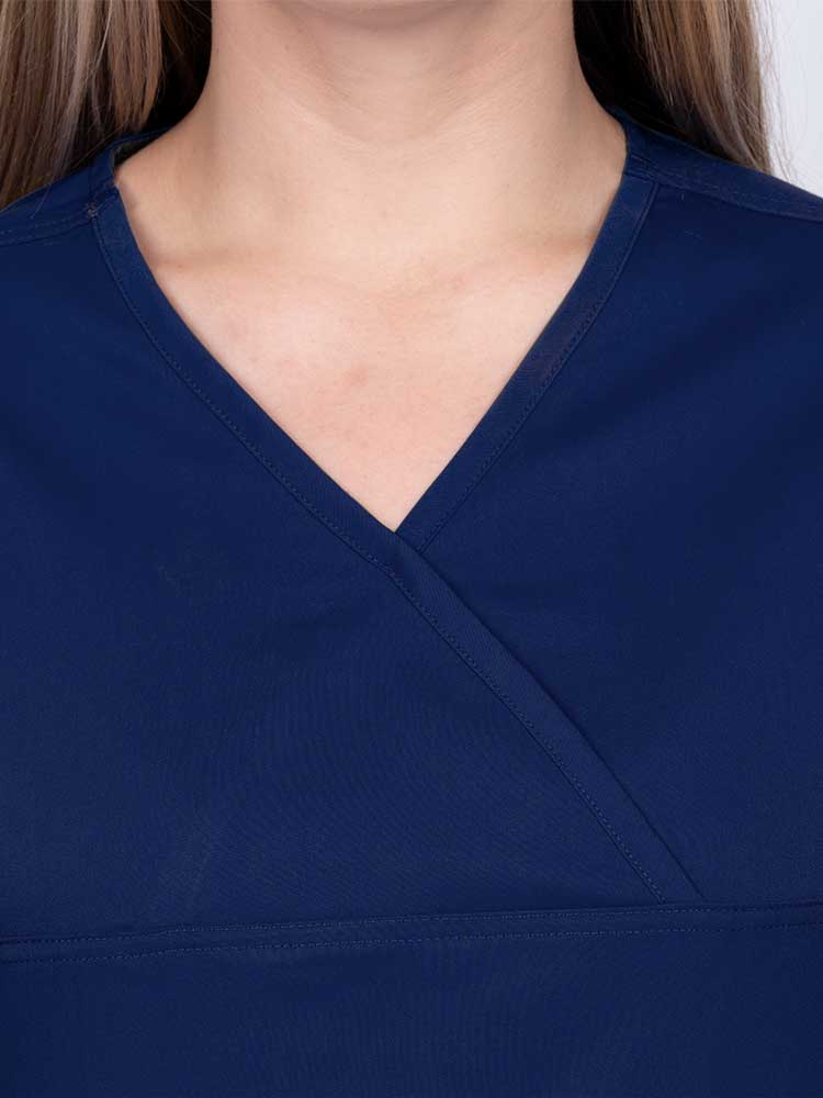 Woman wearing an Epic by MedWorks Women's Scrub Top in navy with a Y-neckline.
