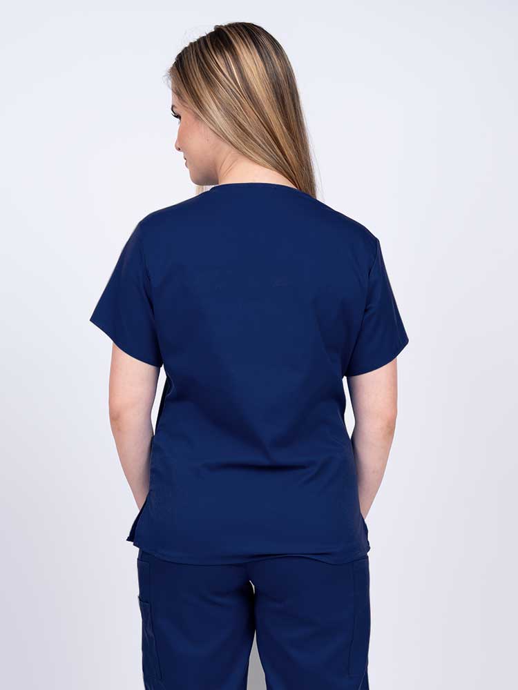 Woman wearing an Epic by MedWorks Women's Y-Neck Scrub Top in navy with a center back length of 26".