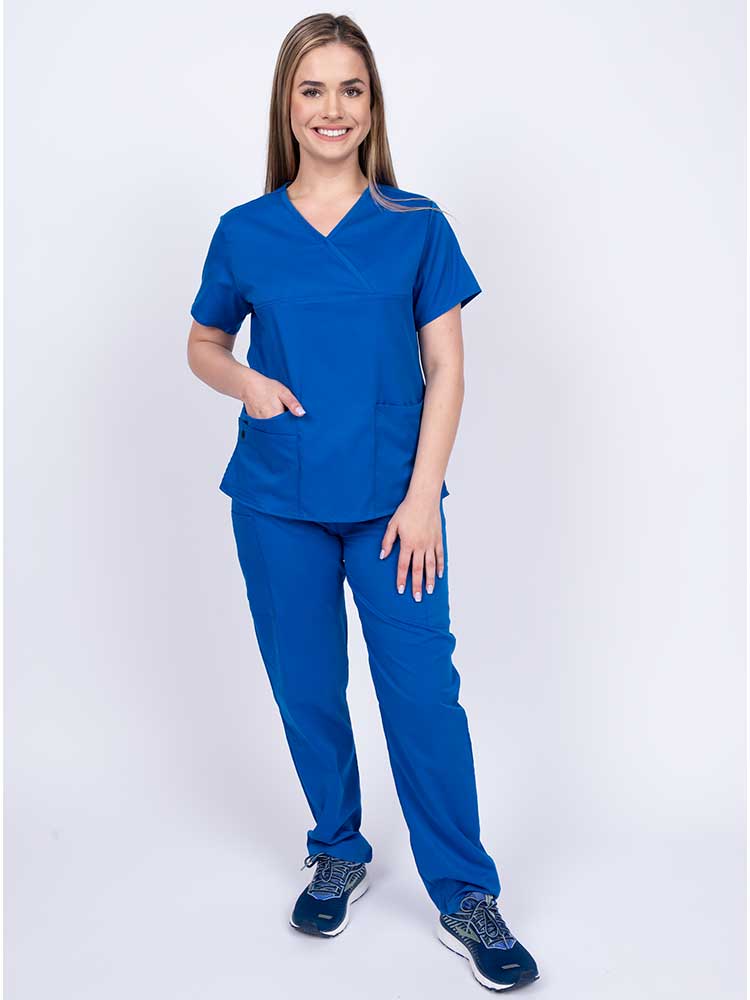 Young woman wearing an Epic by MedWorks Women's Y-Neck Scrub Top in royal with 2 front patch pockets.