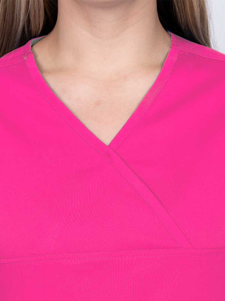 Woman wearing an Epic by MedWorks Women's Scrub Top in shocking pink with a Y-neckline.