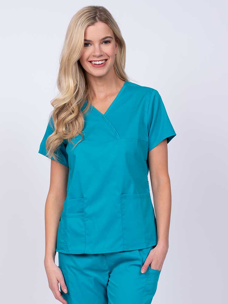 Woman wearing an Epic by MedWorks Women's Y-Neck Scrub Top in teal with a super soft, 2-way stretch fabric designed to move with your body all day long.
