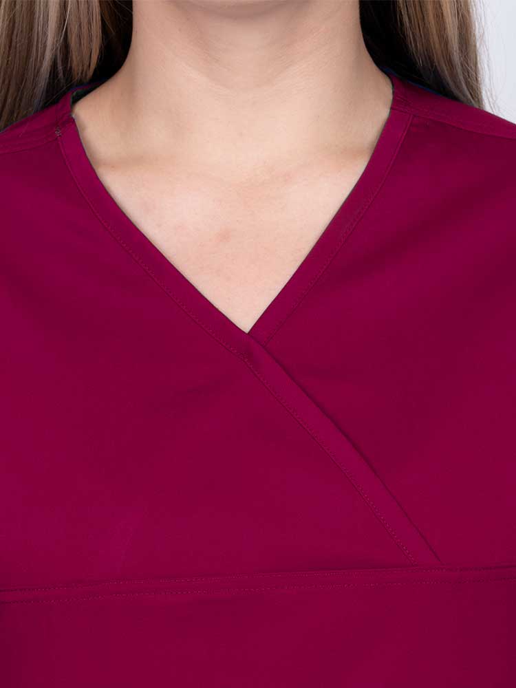 Woman wearing an Epic by MedWorks Women's Scrub Top in wine with a Y-neckline.