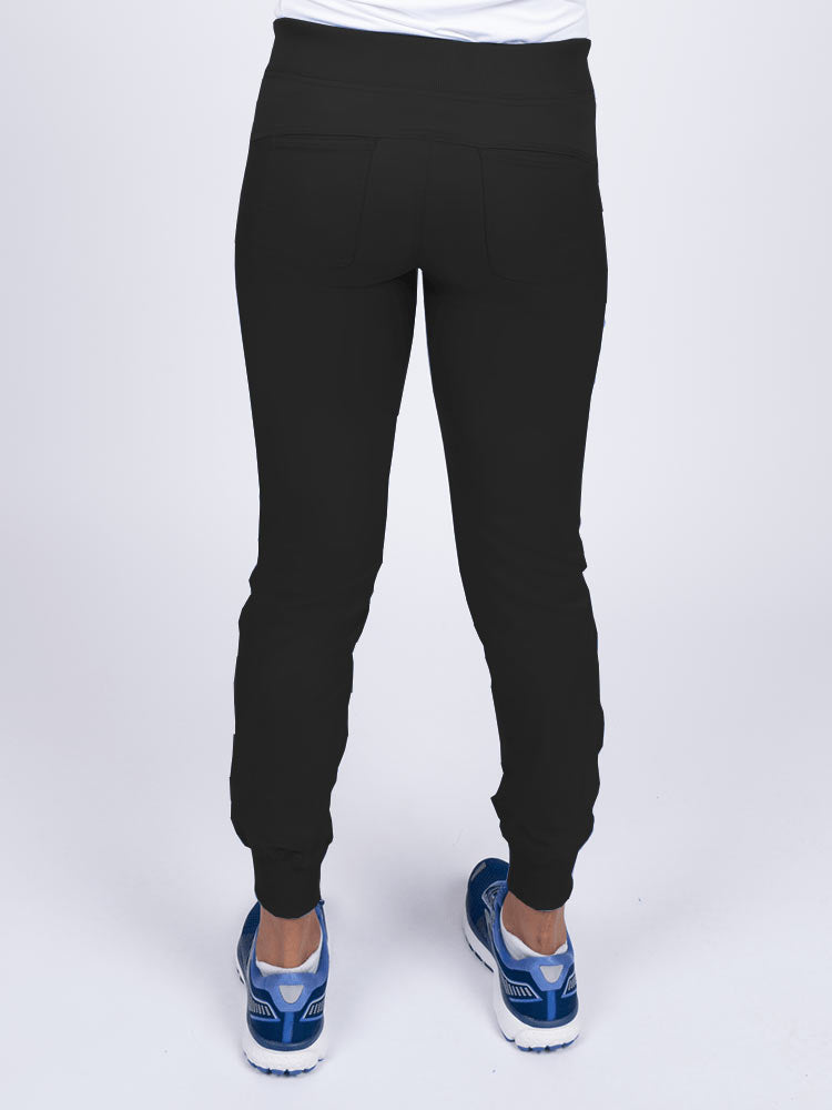 A young female Nurse Practitioner wearing an Epic by MedWorks Women's Yoga Jogger Scrub Pant in Black size small featuring 2 back patch pockets.