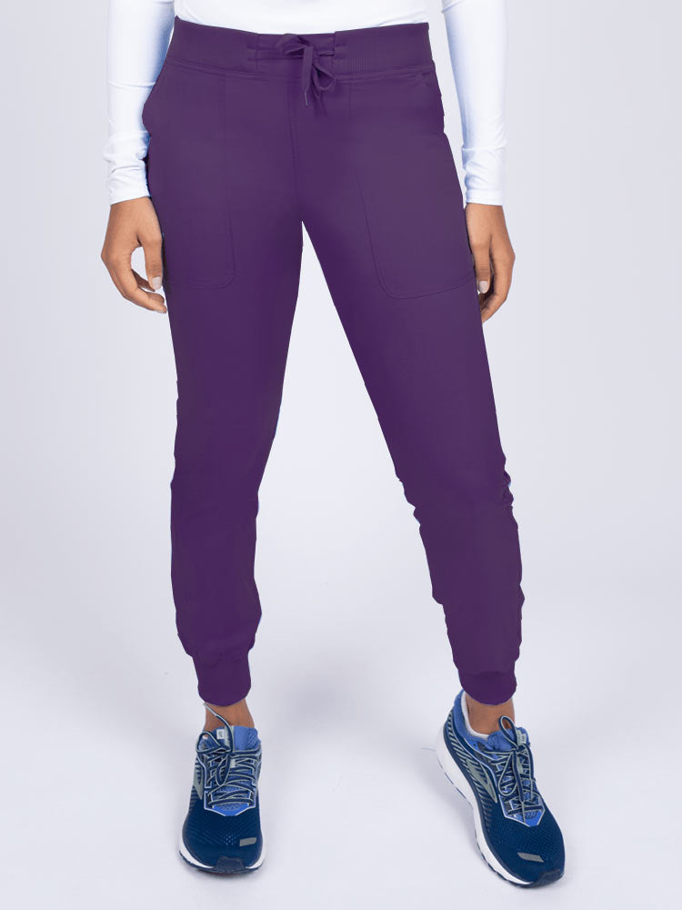 A young female Phlebotomist wearing an Epic by MedWorks Women's Yoga Jogger Scrub Pant in Eggplant size 3XL featuring a contemporary fit.