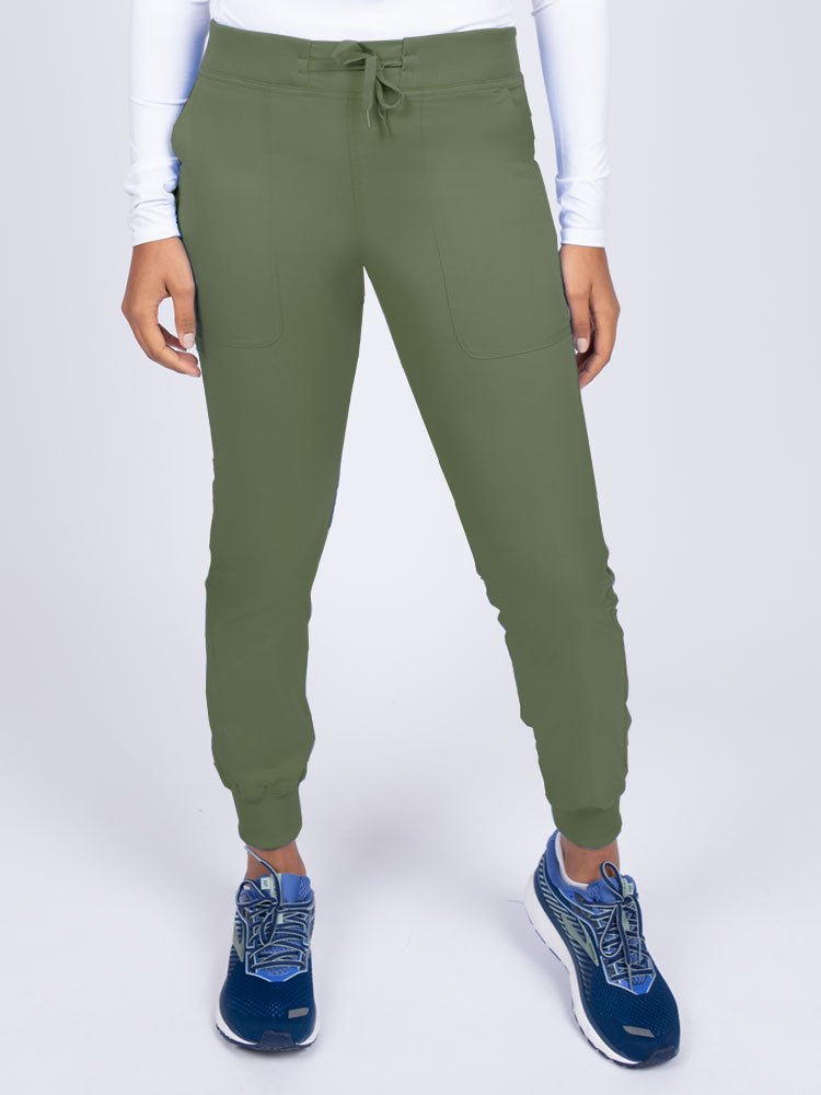 A young female Phlebotomist wearing an Epic by MedWorks Women's Yoga Jogger Scrub Pant in Olive size 3XL featuring a contemporary fit.