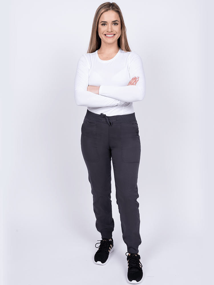 A young female LPN wearing an Epic by MedWorks Women's Yoga Jogger Scrub Pant in Pewter featuring elastic rib knit ankle cuffs.