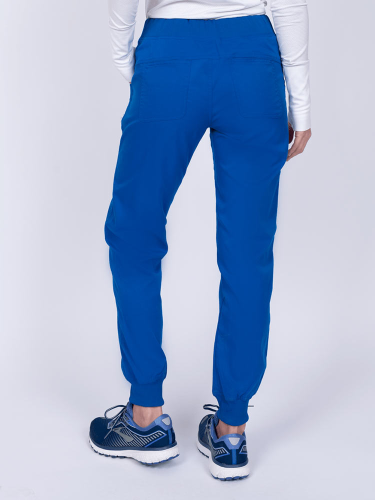 A young female Nurse Practitioner wearing an Epic by MedWorks Women's Yoga Jogger Scrub Pant in Royal size small featuring 2 back patch pockets.