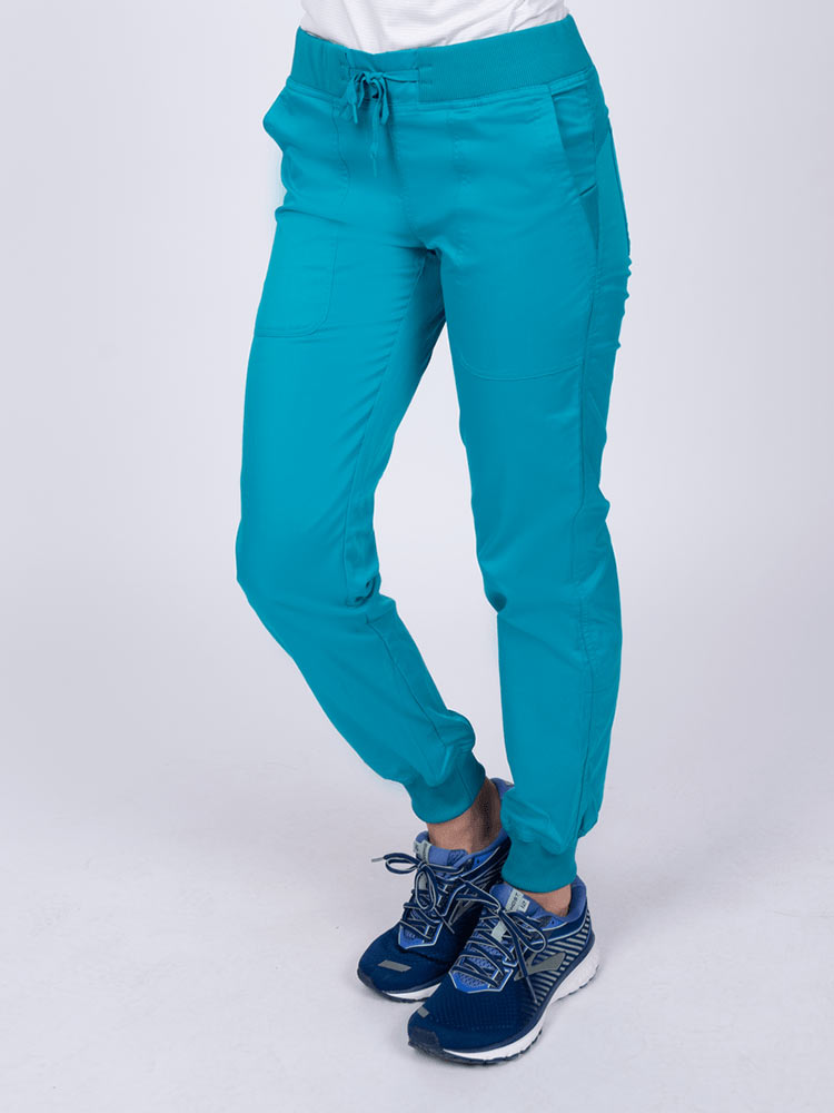 A young female LPN wearing an Epic by MedWorks Women's Yoga Jogger Scrub Pant in Teal  featuring elastic rib knit ankle cuffs.
