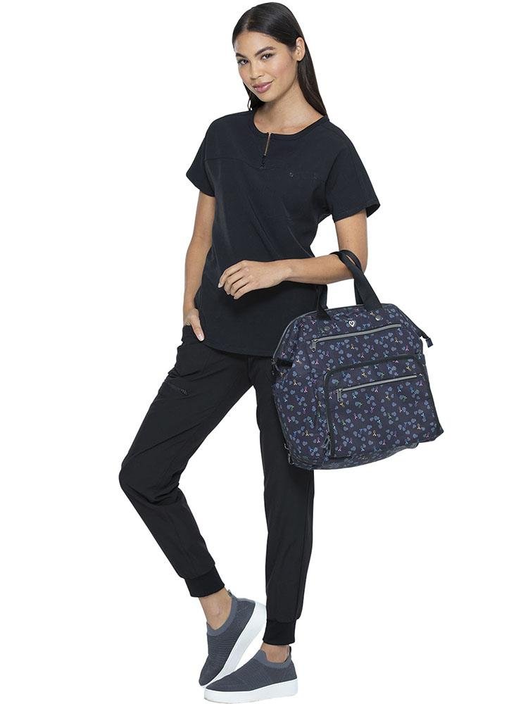 LPN carrying the HeartSoul Bella Backpack in All Awareness Ribbon print featuring a full zipper top closure
