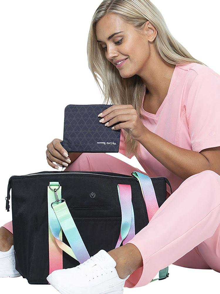Nursing student using her HeartSoul Madison Duffel Bag in Black with Rainbow Straps to organize her nursing school supplies