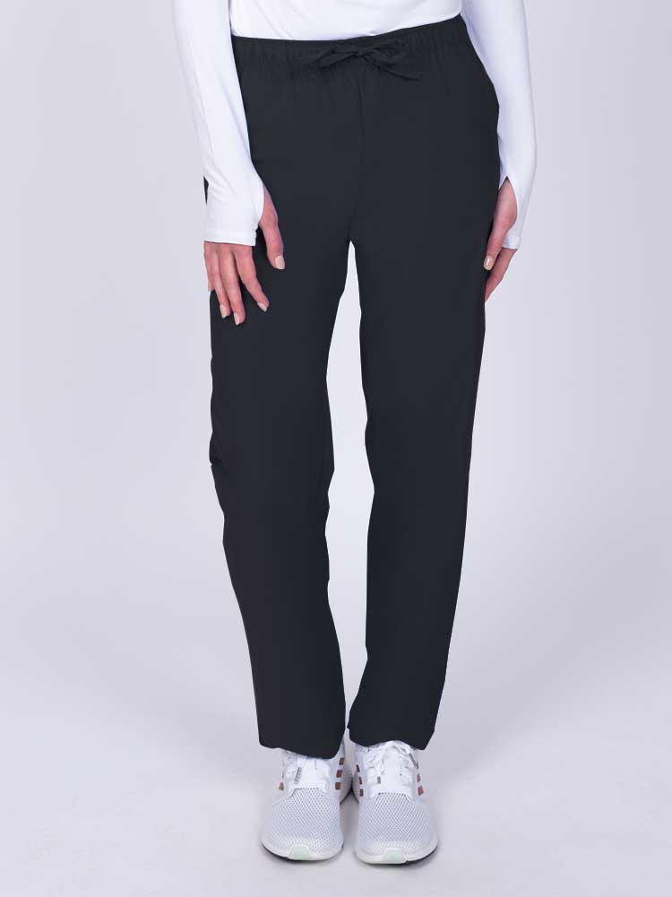 Young woman wearing a Luv Scrubs by MedWorks Women's Elastic Waist Cargo Pant in black featuring one cargo pocket on the wearer's left side.