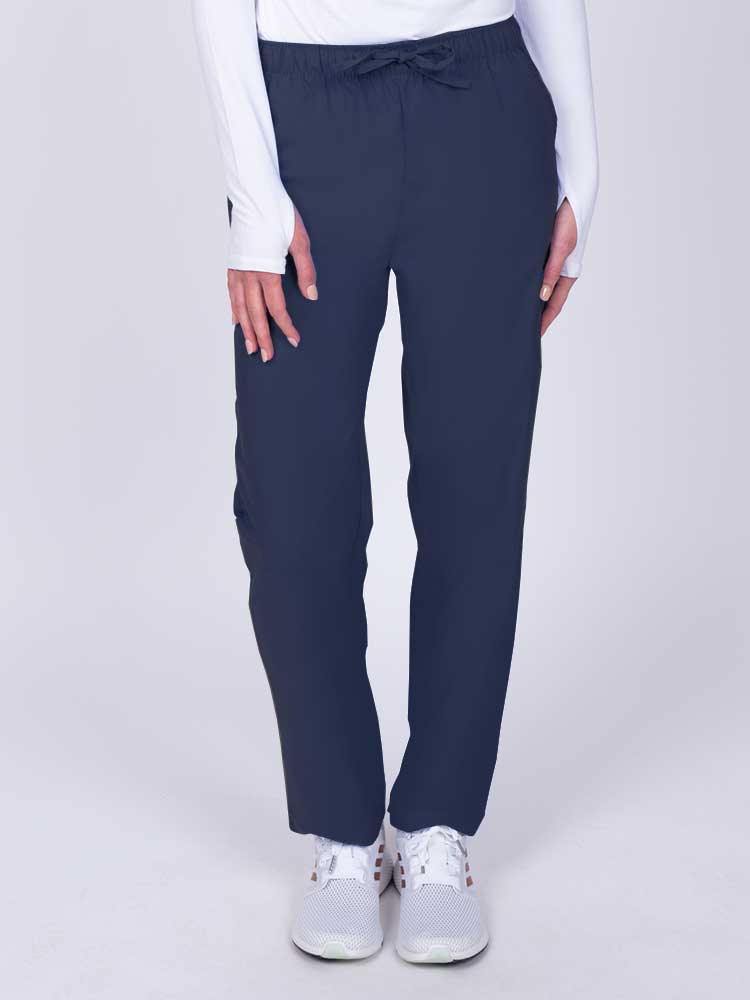 Young woman wearing a Luv Scrubs by MedWorks Women's Elastic Waist Cargo Pant in navy featuring one cargo pocket on the wearer's left side.