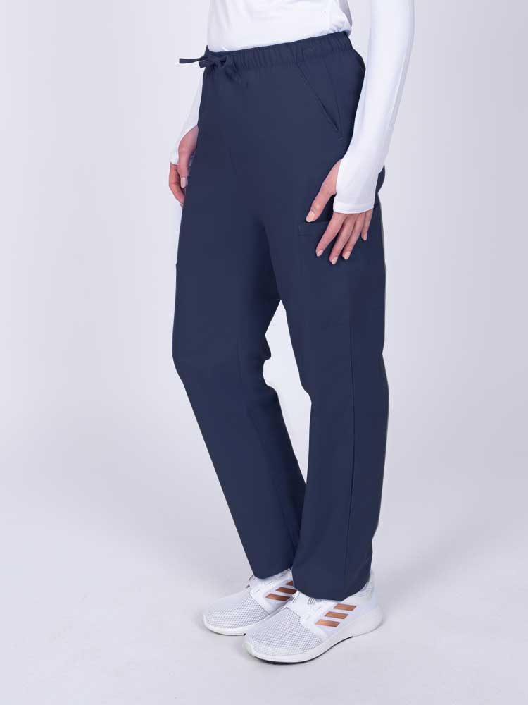 Woman wearing a Luv Scrubs by MedWorks Women's Elastic Waist Cargo Pant in navy with 2 front slash pockets.