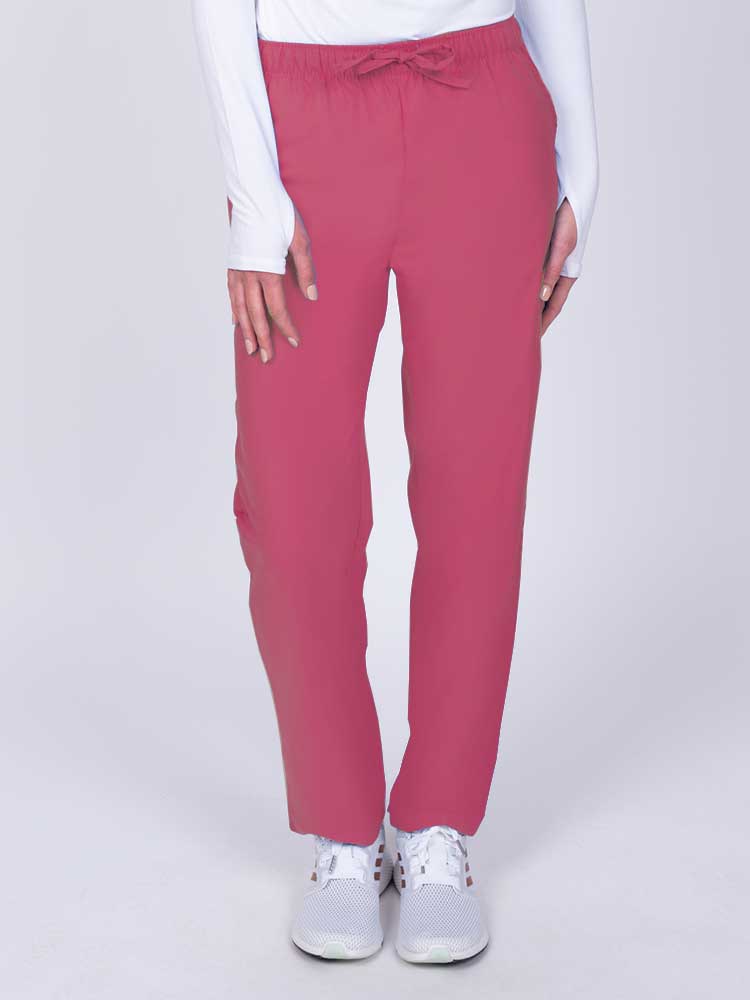 Young woman wearing a Luv Scrubs by MedWorks Women's Elastic Waist Cargo Pant in shocking pink featuring one cargo pocket on the wearer's left side.
