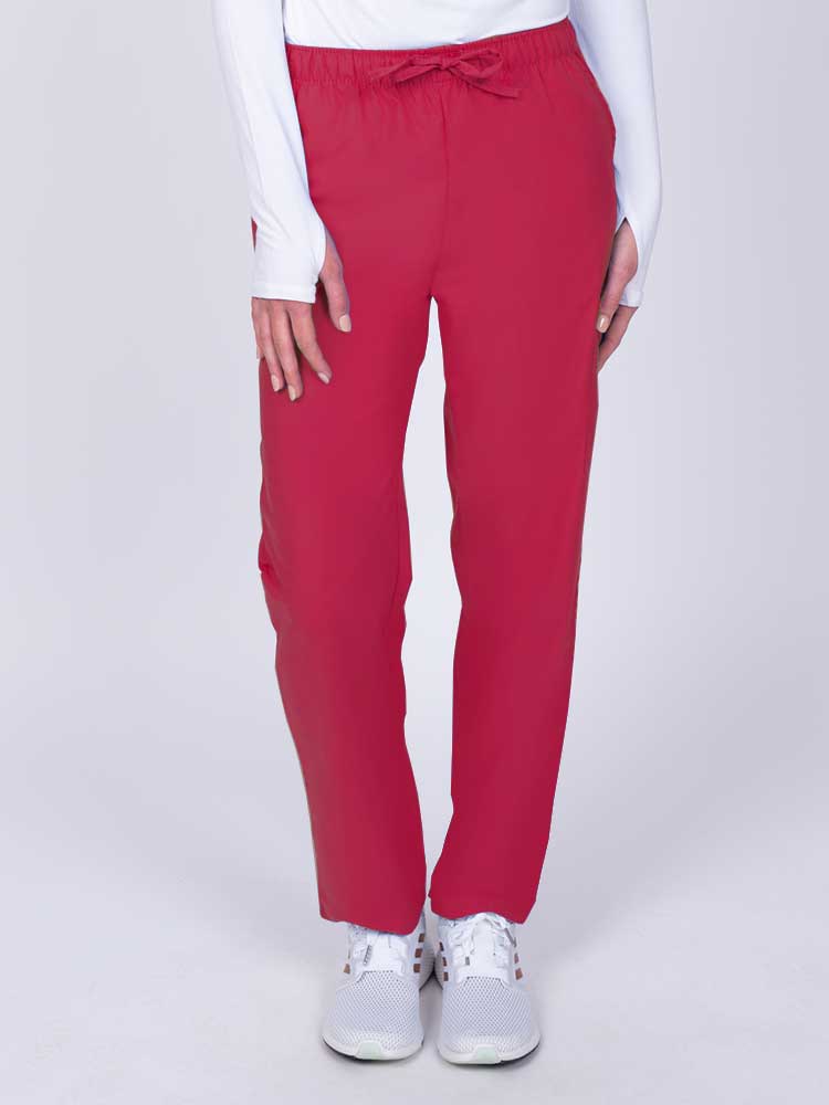 Young woman wearing a Luv Scrubs by MedWorks Women's Elastic Waist Cargo Pant in red featuring one cargo pocket on the wearer's left side.