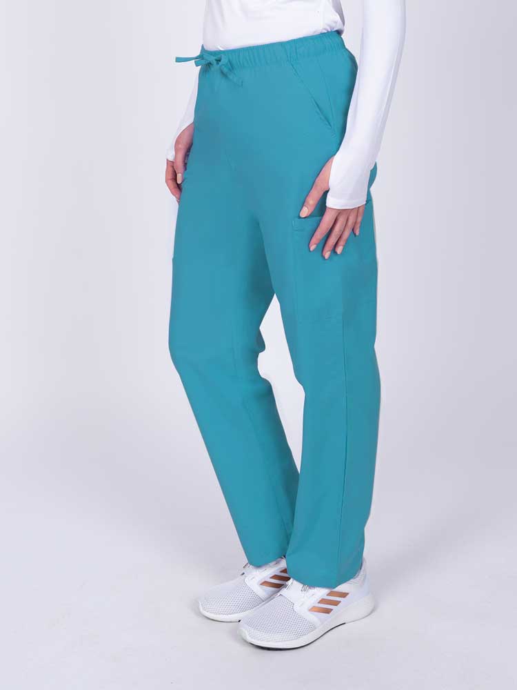 Woman wearing a Luv Scrubs by MedWorks Women's Elastic Waist Cargo Pant in turquoise with 2 front slash pockets.