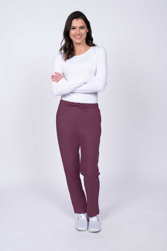 Young healthcare worker wearing a Luv Scrubs by MedWorks Women's Elastic Waist Cargo Pant in wine featuring a natural rise and straight legs.