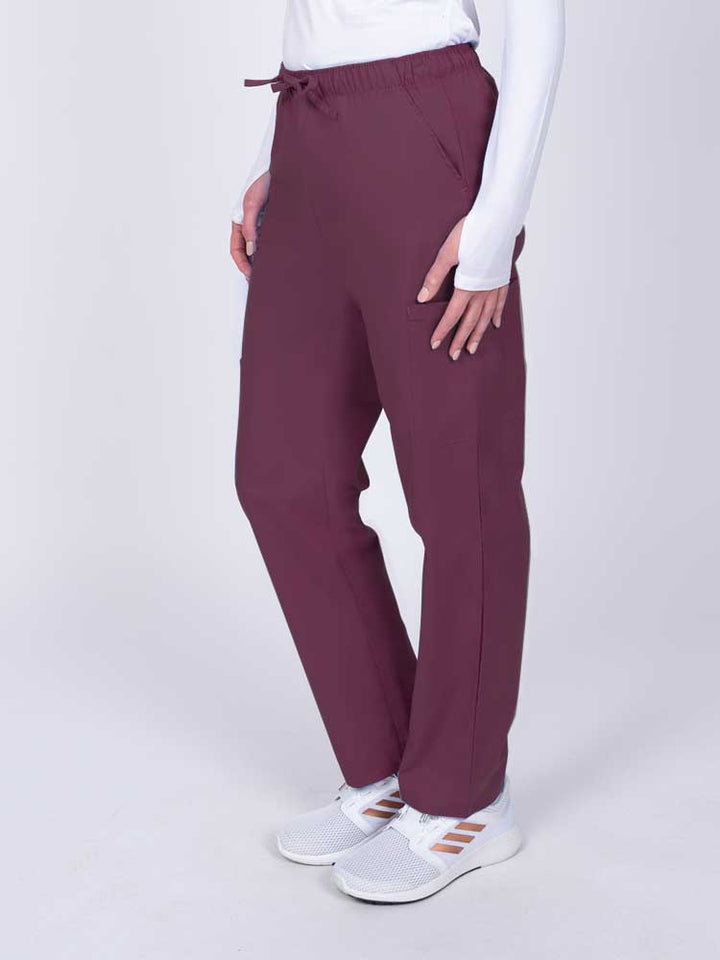 Woman wearing a Luv Scrubs by MedWorks Women's Elastic Waist Cargo Pant in wine with 2 front slash pockets.