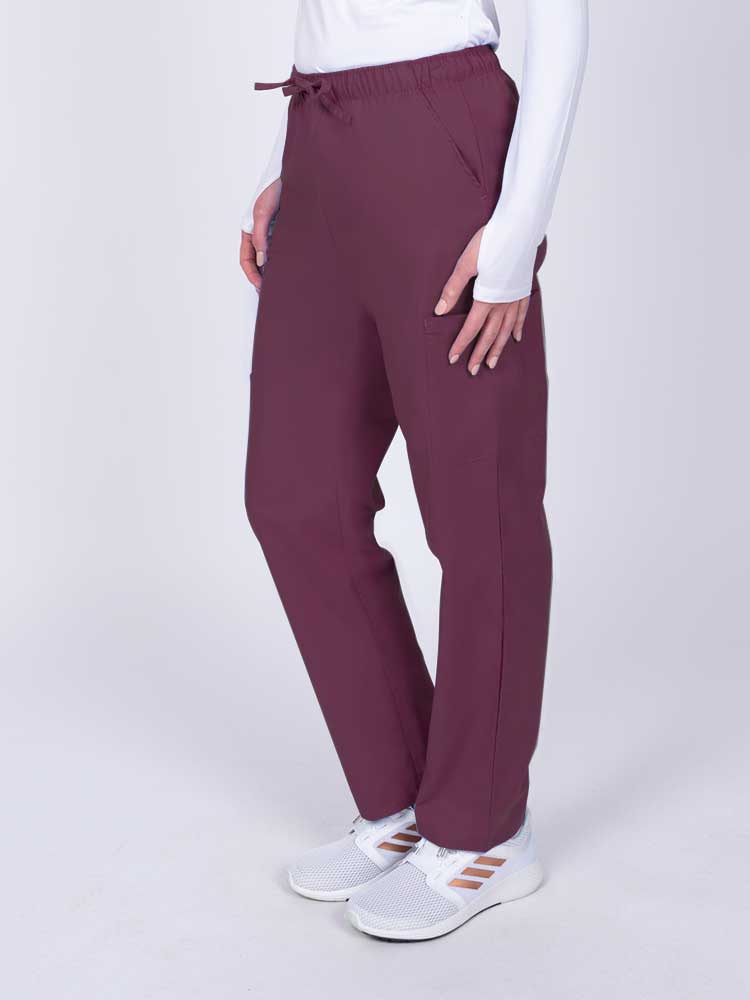Woman wearing a Luv Scrubs by MedWorks Women's Elastic Waist Cargo Pant in wine with 2 front slash pockets.