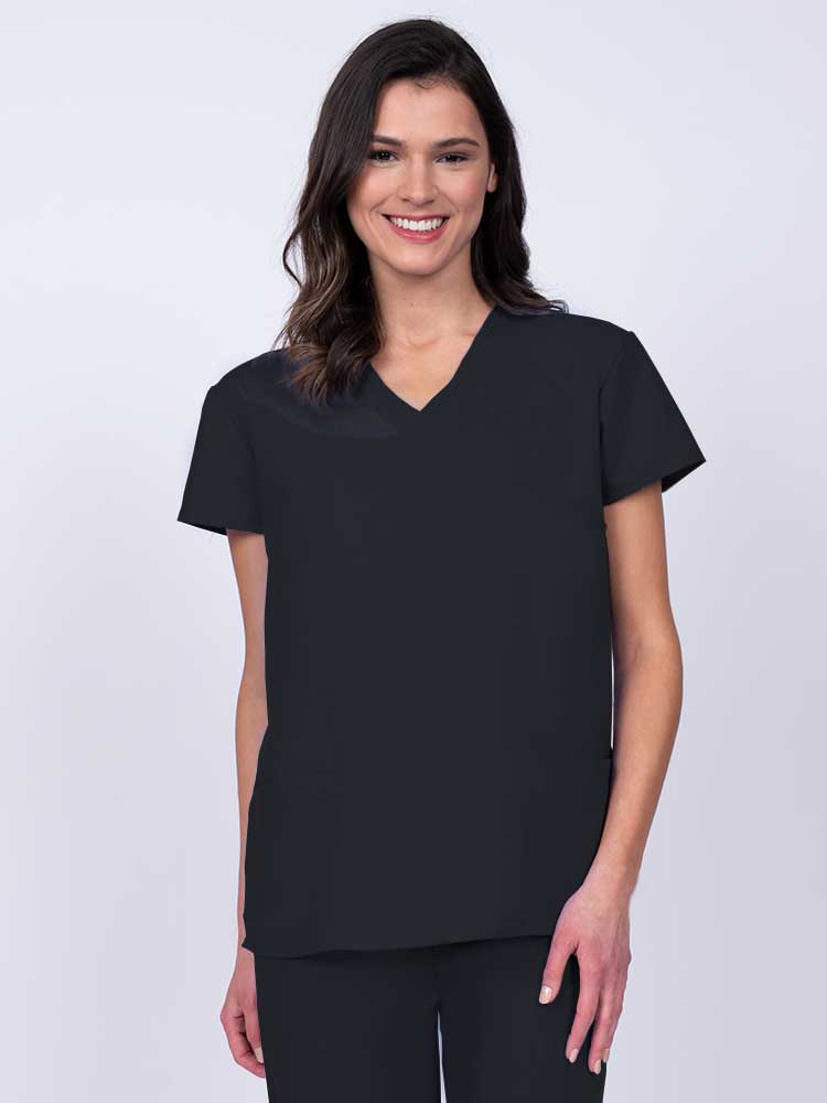 Young woman wearing a Luv Scrubs by MedWorks Women's Mock Wrap Scrub Top in black featuring a Y-neckline and side slits for additional range of motion.