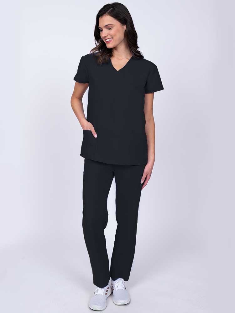 Young healthcare worker wearing a Luv Scrubs by MedWorks Women's Mock Wrap Scrub Top in black with 2 front patch pockets.