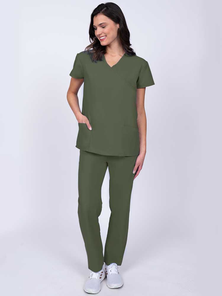 Young healthcare worker wearing a Luv Scrubs by MedWorks Women's Mock Wrap Scrub Top in olive with 2 front patch pockets.