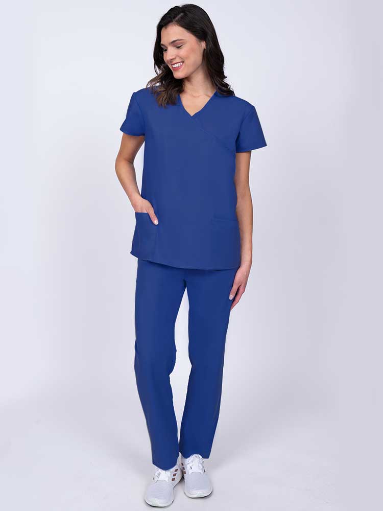 Young healthcare worker wearing a Luv Scrubs by MedWorks Women's Mock Wrap Scrub Top in royal with 2 front patch pockets.