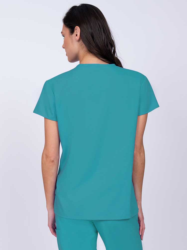 Nurse wearing a Luv Scrubs by MedWorks Women's Mock Wrap Scrub Top in turquoise with shoulder yokes to ensure a flattering fit.