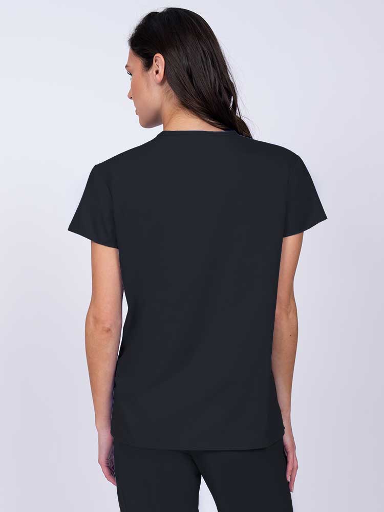 Woman wearing a Luv Scrubs by MedWorks Women's Pocketless Mock Wrap Scrub Top in black with shoulder yokes to ensure a flattering fit.