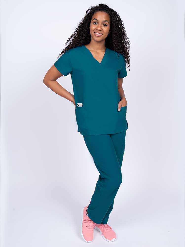 Woman wearing a Luv Scrubs by MedWorks Women's V-neck Scrub Top in Caribbean with 2 front patch pockets.