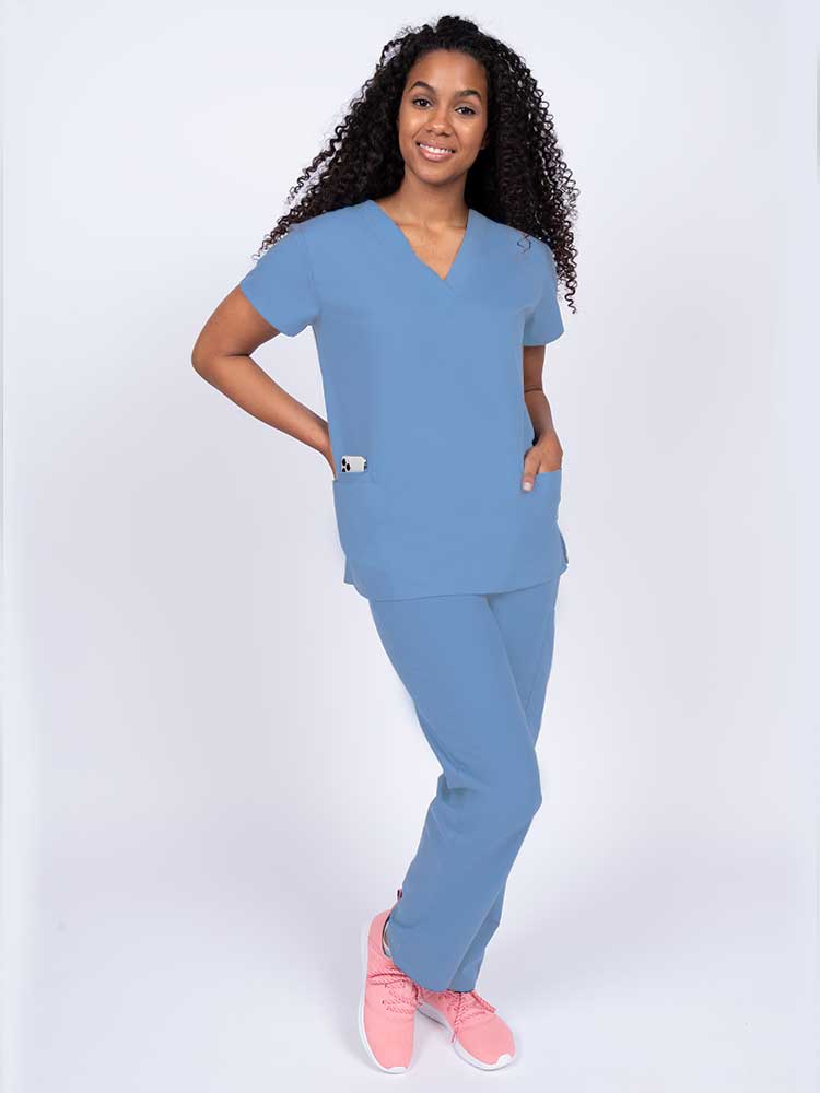Woman wearing a Luv Scrubs by MedWorks Women's V-neck Scrub Top in ceil with 2 front patch pockets.