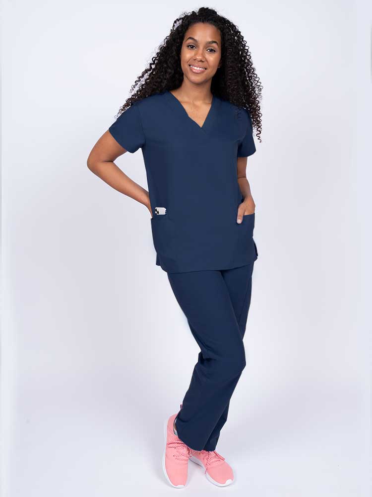 Woman wearing a Luv Scrubs by MedWorks Women's V-neck Scrub Top in navy with 2 front patch pockets.