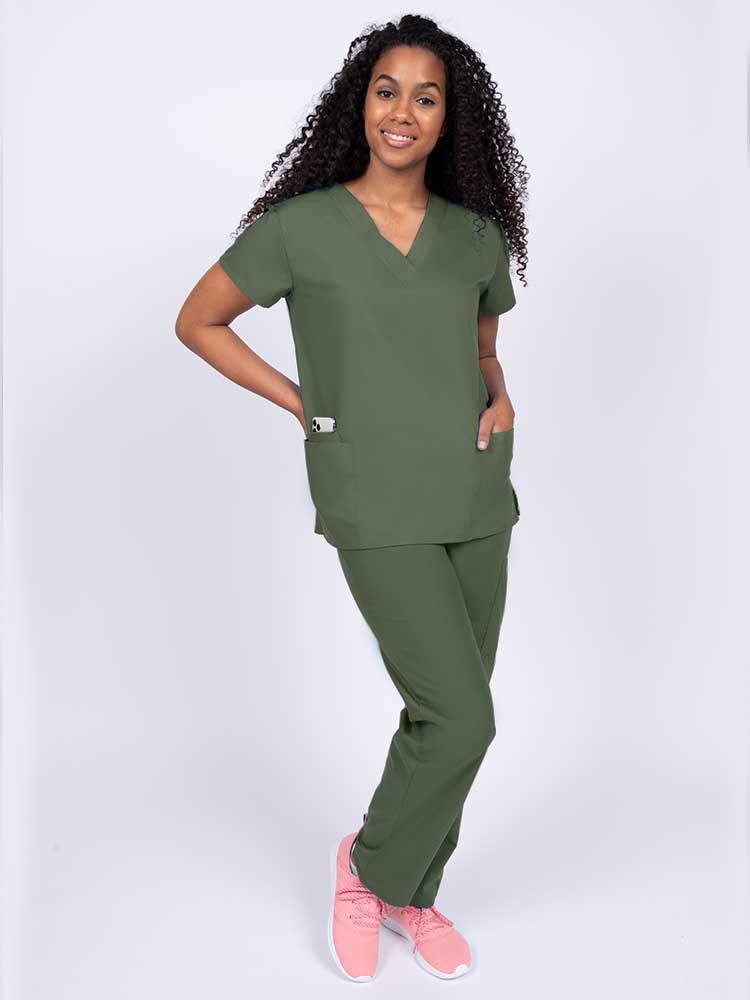 Woman wearing a Luv Scrubs by MedWorks Women's V-neck Scrub Top in olive with 2 front patch pockets.