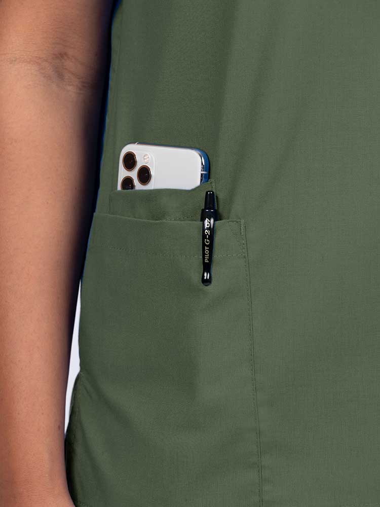 Young female healthcare worker wearing a Luv Scrubs by MedWorks Women's V-neck Scrub Top in olive with a hidden utility pocket/pen slot on wearer's right side.
