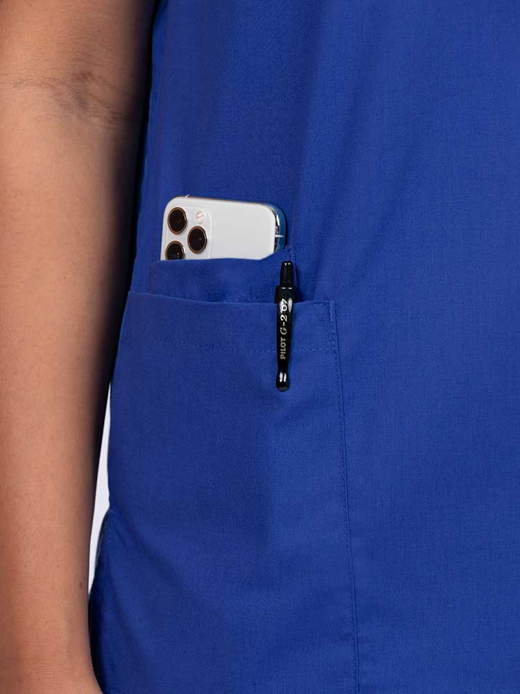 Young female healthcare worker wearing a Luv Scrubs by MedWorks Women's V-neck Scrub Top in royal with a hidden utility pocket/pen slot on wearer's right side.