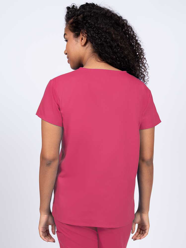 Woman wearing a Luv Scrubs by MedWorks Women's V-neck Scrub Top in shocking pink with a center back length of 26".