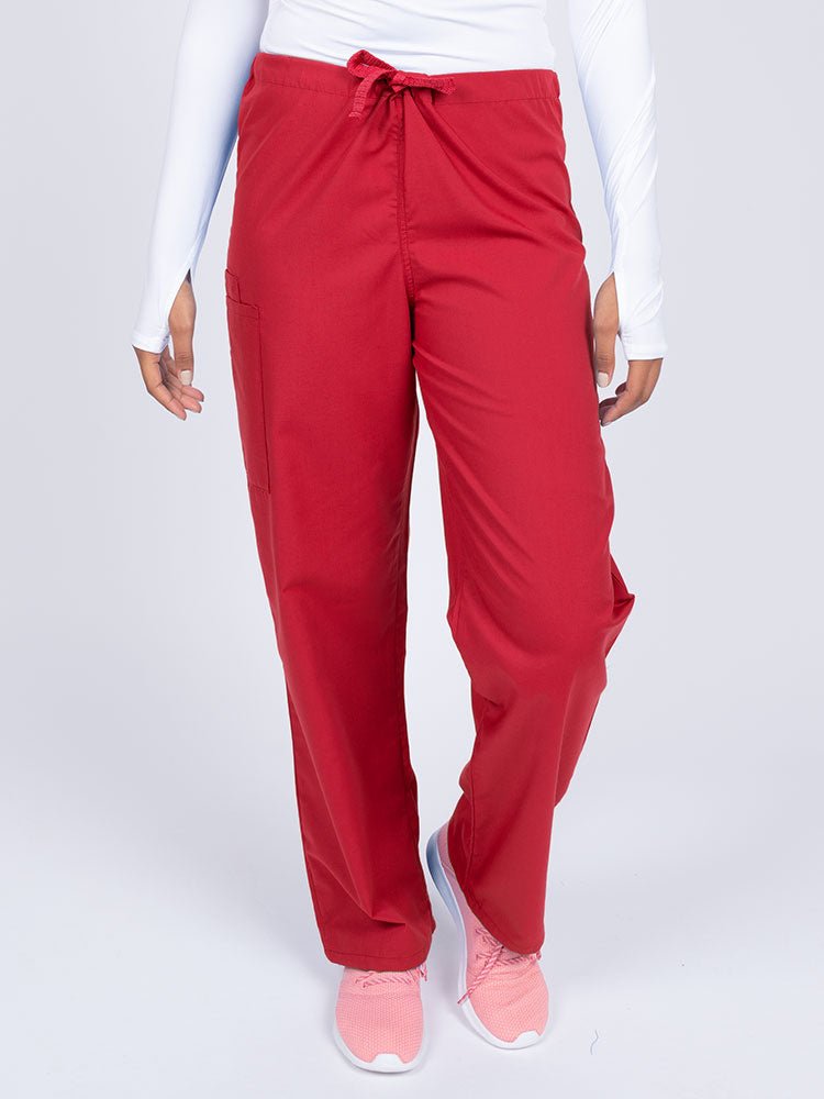 Young female nurse wearing a Luv Scrubs Unisex Drawstring Cargo Pant in Red with a total of 3 pockets.