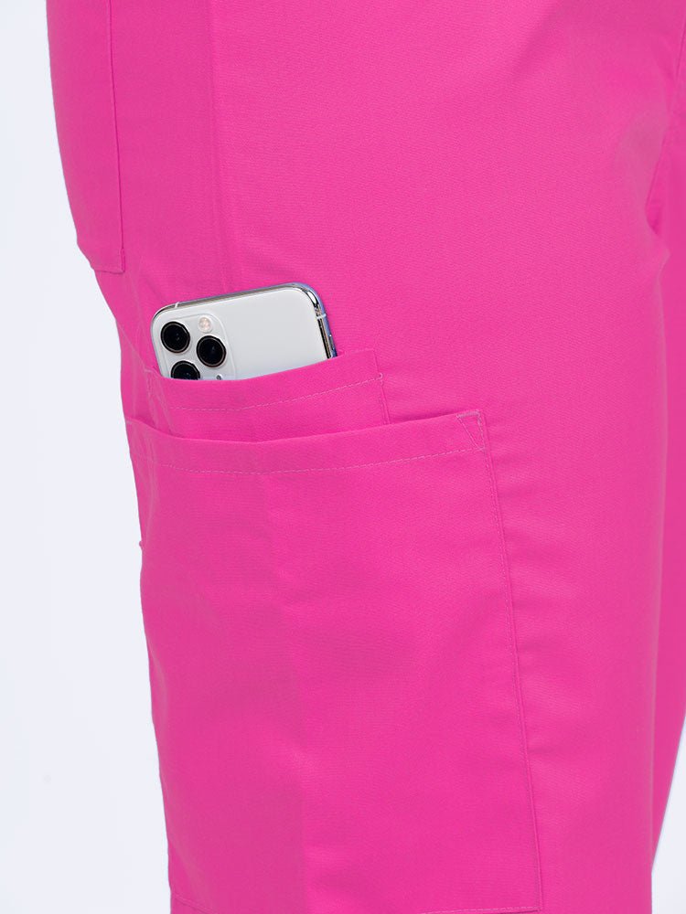 Female nurse wearing a Luv Scrubs Unisex Drawstring Cargo Pant in shocking pink with 1 cargo & cell phone pocket on the wearer's right side.